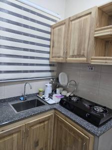 a small kitchen with a sink and a stove at Kibs Apartments in Dodoma