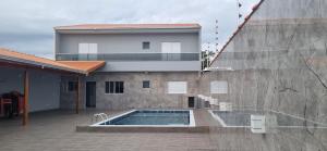 a house with a swimming pool next to a building at Rancho Duarte in Itanhaém