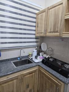a kitchen counter with a sink and a stove at Kibs Apartments in Dodoma +6 photos