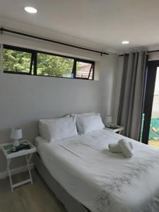 a bedroom with a large white bed with a window at Cosmic View Lodge in East London +21 photos
