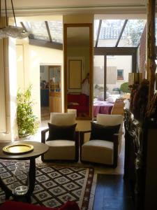 sala de estar con 2 sillas y mesa en Chambres d'hôtes Les Capucins en Bergues