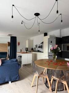 a living room and kitchen with a table and a blue couch at Le repaire du raton laveur in Rance
