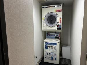 a washing machine and a washer in a room at Pioland Hotel in Saitama