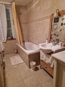 a bathroom with a tub and a sink and a bath tub at CHARM & FOLIe in Praslin