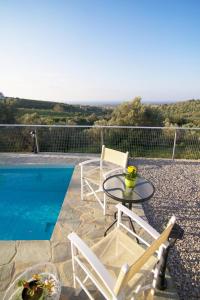 a patio with a table and chairs next to a pool at Iperion Apartment G2-2 in Agia Triada