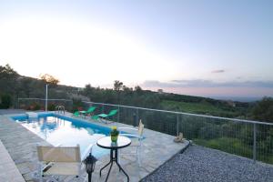 a villa with a swimming pool with a table and chairs at Iperion Apartment G2-2 in Agia Triada