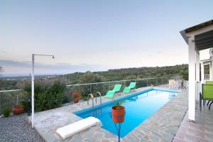 a swimming pool with green chairs on a house at Iperion Apartment G2-2 in Agia Triada