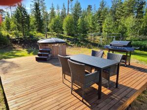 a wooden deck with a table and chairs and a grill at Villa Sierijärvi in Rovaniemi