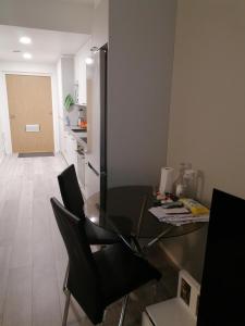 a dining room with a glass table and black chairs at Prince Palace in Vantaa