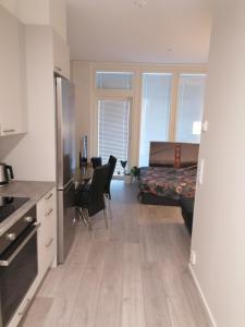 a kitchen and living room with a desk and a bed at Prince Palace in Vantaa
