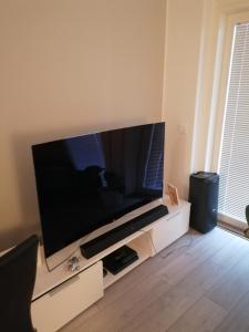 a large flat screen tv sitting on a white entertainment center at Prince Palace in Vantaa