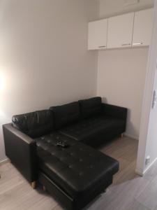 a black leather couch in a living room at Prince Palace in Vantaa