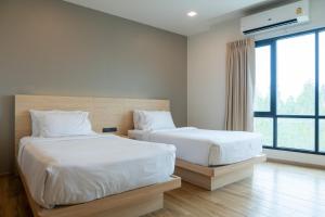 a bedroom with two beds and a large window at Mayuu Ayutthaya Hotel in Ban Ko Rian +53 photos