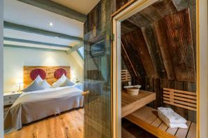 a bedroom with a bed and a wooden wall at Hotel Wellness Goldenes Fass Meißen in Meißen