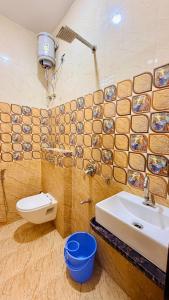 a bathroom with a sink and a toilet at Hotel Parth Inn in Indore