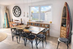 a dining room with a table and chairs and a surfboard at Bali Spirit - Toplage Usingen in Usingen