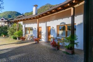 a white house with a patio with a table and chairs at Vogelmaierhof am Kalterer See in Caldaro