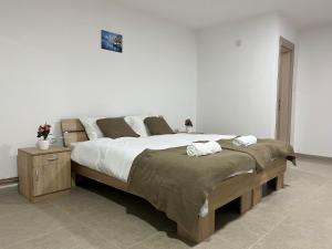 a bedroom with a large bed with white sheets at Etno kuca Brzece in Brzeće