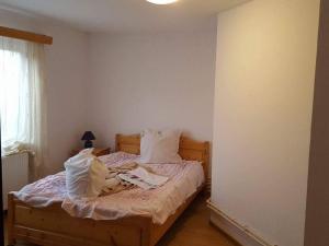 a bedroom with a bed with white sheets and pillows at Pensiunea Cristomar in Bran