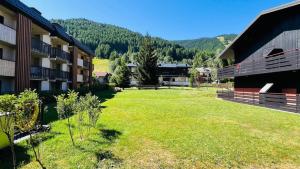 a large yard next to a building with a grass field at Elegante suite con box privato e vista in Aprica