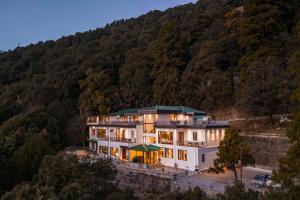 a large white house in the middle of a mountain at Moustache Select Nainital- Onsite Parking in Nainital