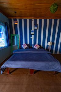 a bedroom with a large bed with blue and white stripes at Backpacker Storey in Bīr