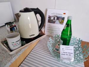 a table with a coffee maker and a bottle of water at Gästehaus AM HERMANN in Hörstel