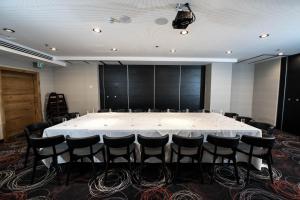 uma grande sala de conferências com uma mesa e cadeiras brancas em Eyal Hotel by Smart Hotels em Jerusalém