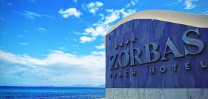 a sign for a zorba hotel on the beach at Zorbas Beach Hotel in Tigaki