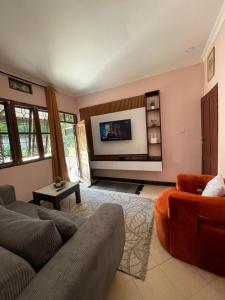 a living room with a couch and a tv at Serene homes in Mwanza