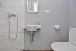 a white bathroom with a sink and a toilet at Wanderlust Guest House Prime Location in Yerevan