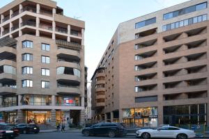 two tall buildings with cars parked in front of them at Wanderlust Guest House Prime Location in Yerevan