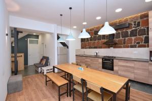 a kitchen with a wooden table and chairs at Wanderlust Guest House Prime Location in Yerevan