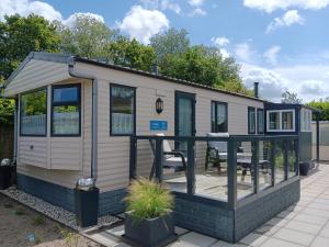 a tiny house with a deck in a yard at 't Kotje Ouddorp in Ouddorp