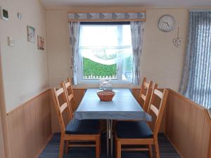 a dining room table with chairs and a window at 't Kotje Ouddorp in Ouddorp