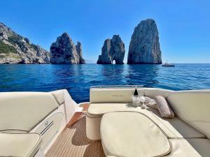 a boat on the water with rocks in the water at Palermo Boat Experience in Isola delle Femmine