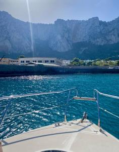 a boat in the water with mountains in the background at Palermo Boat Experience in Isola delle Femmine