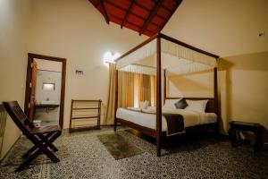 a bedroom with a canopy bed and a mirror at Akruthi Palm Pavilion Resort in Aldūr