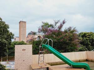 a playground with a green slide in a park at quarto casal in Aparecida