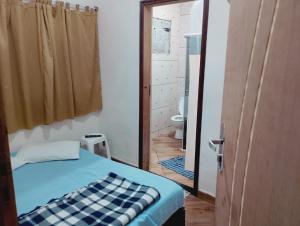 a bedroom with a bed and a bathroom with a toilet at quarto casal in Aparecida