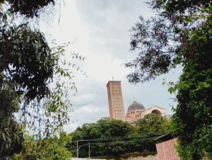 a tall building with a clock tower in the distance at quarto casal in Aparecida