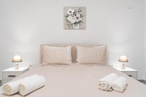 a bedroom with a white bed with two towels on it at Greca Apartments in Sauk