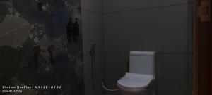 a bathroom with a white toilet in a room at Hotel Eden Palace in Trichūr