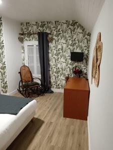 a bedroom with a bed and a tv on a wall at Le Declic in Bayeux