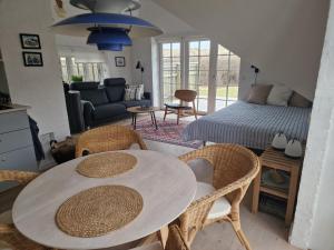 a living room with a table and chairs and a bed at Fiskerhuset in Agger