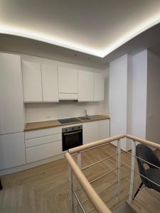 a kitchen with white cabinets and a stove top oven at Elegante suite con box privato e vista in Aprica