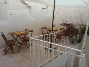 a patio with tables and chairs and an umbrella at Donna Sicilia Ortigia in Syracuse