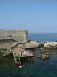 a group of people in the water near a castle at Donna Sicilia Ortigia in Syracuse