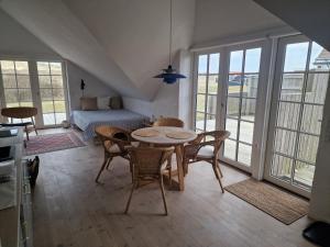a living room with a table and chairs and a couch at Fiskerhuset in Agger +22 photos