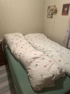 an unmade bed with a comforter on top of it at Holiday home for rent in Lyngen